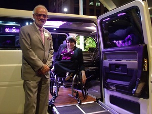 Man standing with woman in wheelchair in an accessible car